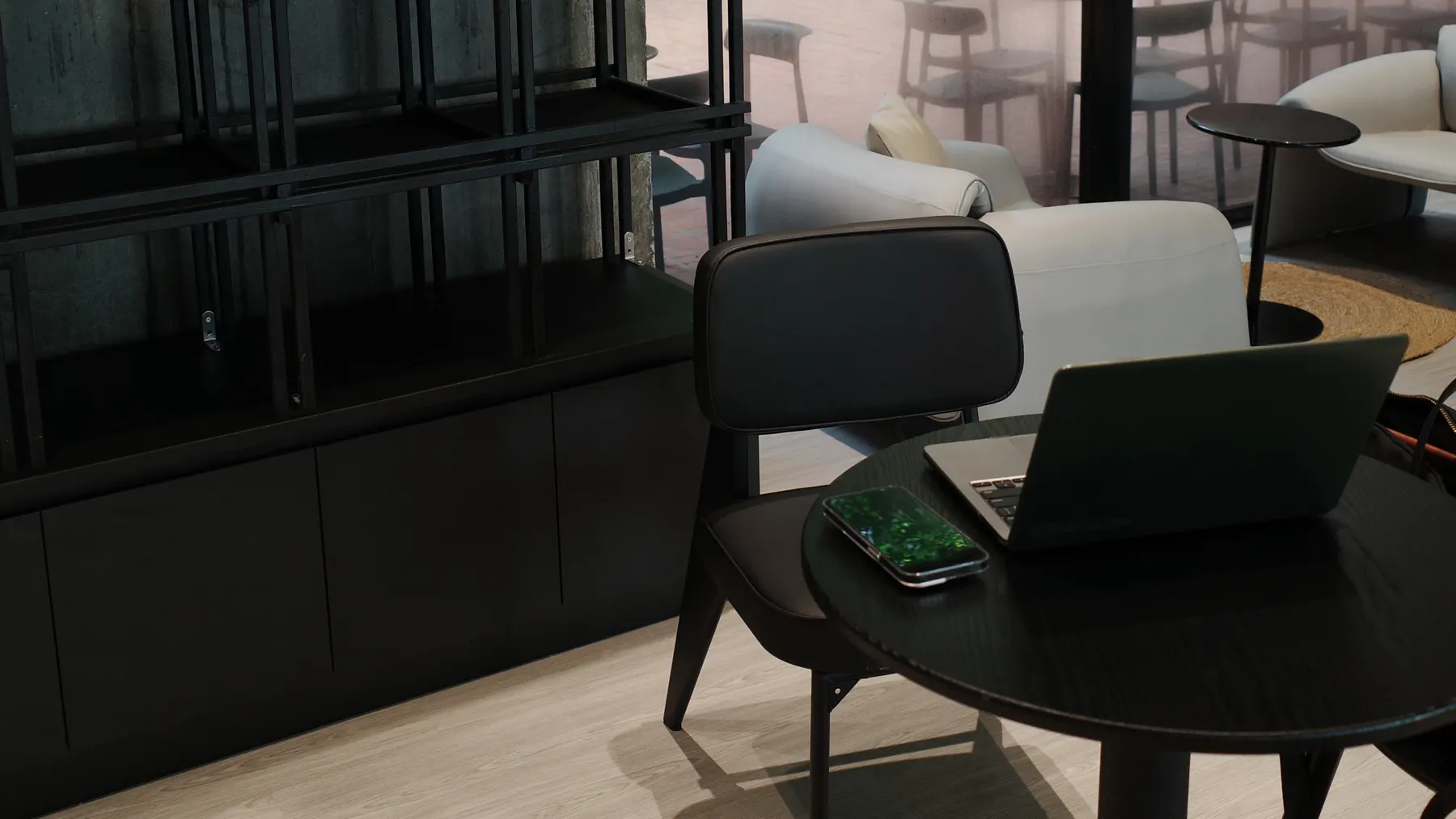A quiet corner of a modern lounge with a laptop open on a low round table